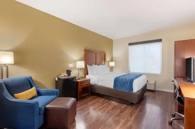 a hotel room with a bed and a chair at Comfort Inn & Suites Near Ontario Airport in Ontario