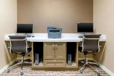 a desk with two monitors and a printer and two chairs at Comfort Inn & Suites Near Ontario Airport in Ontario