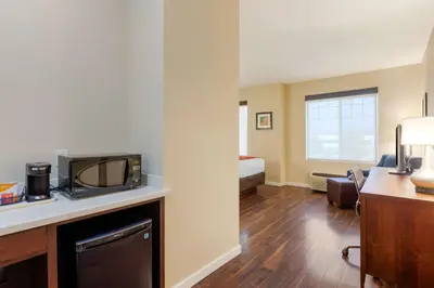 a hotel room with a desk with a television and a bed at Comfort Inn & Suites Near Ontario Airport in Ontario