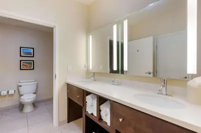a bathroom with two sinks and a toilet at Comfort Inn & Suites Near Ontario Airport in Ontario