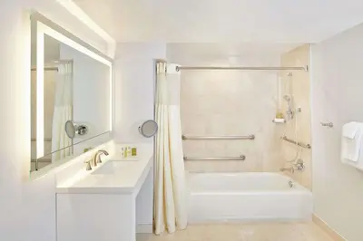 a white bathroom with a tub and a sink at DoubleTree by Hilton Torrance - South Bay in Torrance