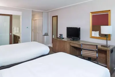 a hotel room with two beds and a desk with a television at DoubleTree by Hilton Torrance - South Bay in Torrance
