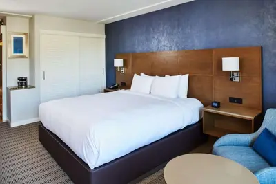 a hotel room with a large bed and a chair at DoubleTree by Hilton Torrance - South Bay in Torrance