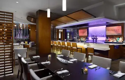 a restaurant with tables and chairs and a bar at Hilton Woodland Hills/ Los Angeles in Woodland Hills