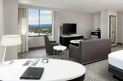 a hotel room with a couch and a television at Hilton Woodland Hills/ Los Angeles in Woodland Hills