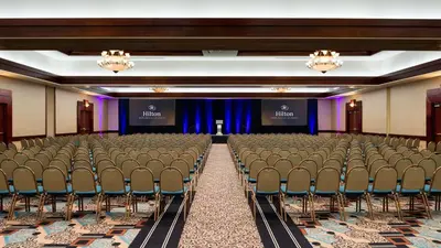 an empty room with rows of chairs and a stage at Hilton Woodland Hills/ Los Angeles in Woodland Hills