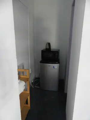 a small room with a microwave on top of a trash can at Wilshire Orange Hotel in Los Angeles
