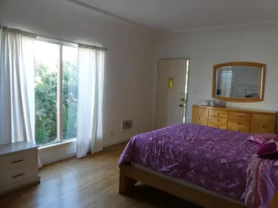 a bedroom with a bed and a mirror and a window at Wilshire Orange Hotel in Los Angeles
