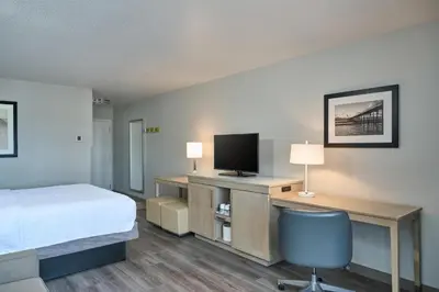 a hotel room with a bed and a desk with a television at Hampton Inn & Suites Hermosa Beach in Hermosa Beach