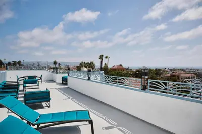 a balcony with blue lounge chairs on a roof at Hampton Inn & Suites Hermosa Beach in Hermosa Beach