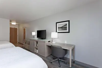 a hotel room with a desk with a computer and a bed at Hampton Inn & Suites Hermosa Beach in Hermosa Beach