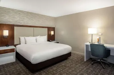 a hotel room with a large white bed and a desk at DoubleTree by Hilton Monrovia - Pasadena Area in Monrovia