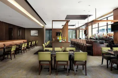 a restaurant with tables and chairs and a bar at DoubleTree by Hilton Monrovia - Pasadena Area in Monrovia