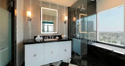 a bathroom with a sink and a tub and a mirror at The Beverly Hilton in Los Angeles
