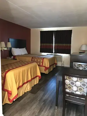 a hotel room with two beds and a window at Manhattan Inn & Suites in Manhattan Beach