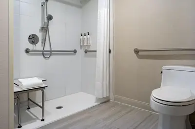 a bathroom with a shower and a toilet at Delta Hotels by Marriott Ontario Airport in Ontario