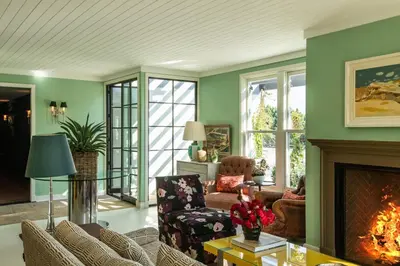 a living room with green walls and a fireplace at Hotel 850 SVB, West Hollywood, a Member of Design Hotels in Los Angeles