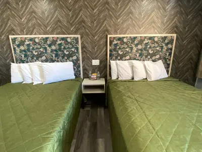 two green beds sitting next to each other in a room at Harbor Inn in Harbor City