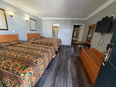 a hotel room with two beds and a flat screen tv at Harbor Inn in Harbor City