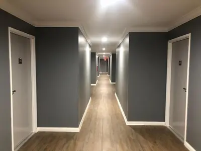 an empty hallway with a long hall with blue walls at ERTH INN by AGA Los Angeles in Los Angeles