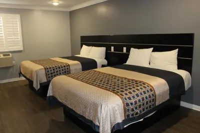 a hotel room with two beds and a window at ERTH INN by AGA Los Angeles in Los Angeles