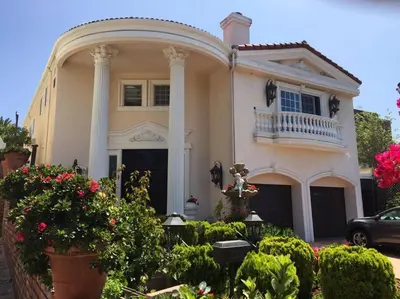 a large white house with pillars and flowers at Entire Second Flr - Santa Monica Luxury Roman Villa in Los Angeles
