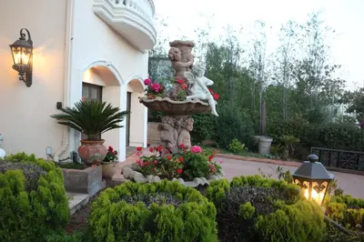 a garden in front of a house with a statue at Entire Second Flr - Santa Monica Luxury Roman Villa in Los Angeles