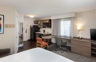 a hotel room with a desk and a kitchen at Candlewood Suites Anaheim - Resort Area by IHG in Anaheim