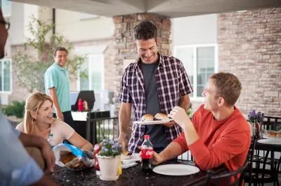 a man holding a plate of food at a table at Candlewood Suites Anaheim - Resort Area by IHG in Anaheim