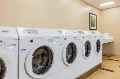 a row of white washing machines in a laundry room at Candlewood Suites Anaheim - Resort Area by IHG in Anaheim