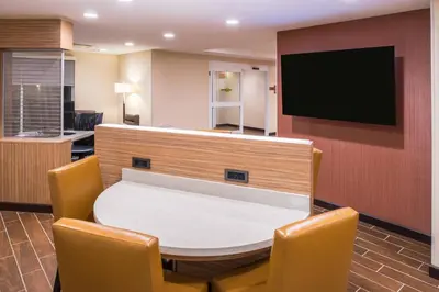 a room with a table and chairs and a flat screen tv at TownePlace Suites by Marriott Ontario Chino Hills in Chino Hills