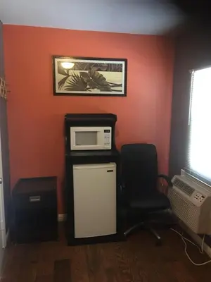 a room with a chair and a microwave at Route 66 Motel - Rialto in Rialto