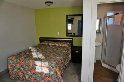 a bedroom with a bed and a sink and a mirror at Route 66 Motel - Rialto in Rialto