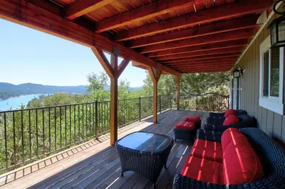 a porch with a couch and chairs on a deck at Mountain Top Chalet in Lake Arrowhead