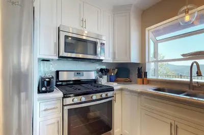 a kitchen with a stove and a microwave at Mountain Top Chalet in Lake Arrowhead