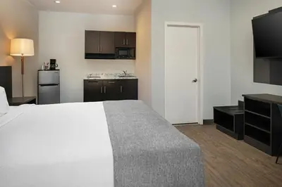 a hotel room with a bed and a kitchen at Route 66 Motel in Barstow