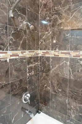 a bathroom with a marble tile wall with a shower at Redondo Beach Inn-LAX in Gardena