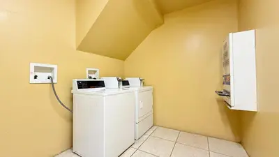 a washer and dryer in a room with yellow walls at Redondo Beach Inn-LAX in Gardena