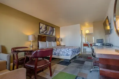 a hotel room with a bed and a table and chairs at National 9 Inns in Buttonwillow