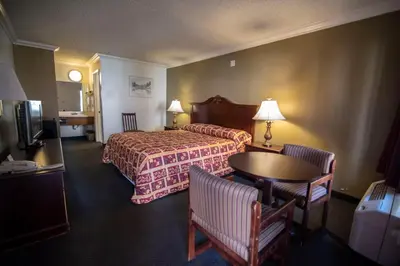 a hotel room with a bed and a table and chairs at National 9 Inns in Buttonwillow