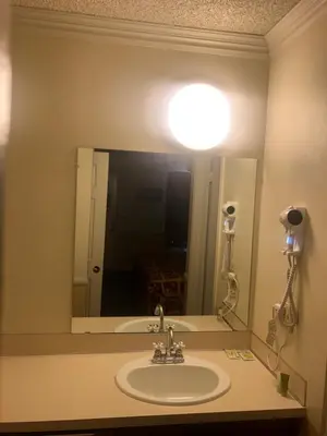 a bathroom with a sink and a large mirror at National 9 Inns in Buttonwillow