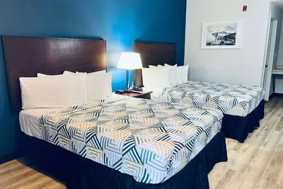 two beds in a hotel room with blue walls at Baymont by Wyndham Ridgecrest in Ridgecrest