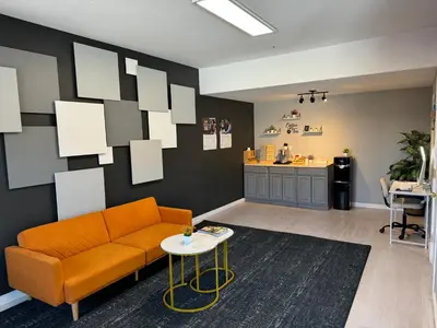a living room with an orange couch and a table at Baymont by Wyndham Ridgecrest in Ridgecrest