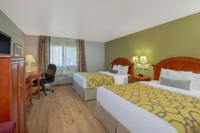 a hotel room with two beds and a desk at Baymont by Wyndham Tehachapi in Tehachapi