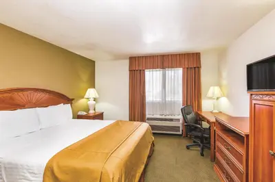 a hotel room with a bed and a desk and a television at Baymont by Wyndham Tehachapi in Tehachapi