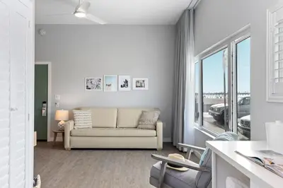 a living room with a couch and a large window at Sea Sprite Beach Club in Hermosa Beach