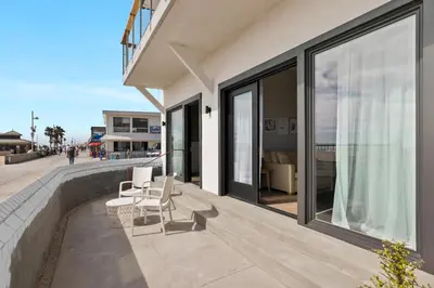 a house with a patio with two chairs and windows at Sea Sprite Beach Club in Hermosa Beach