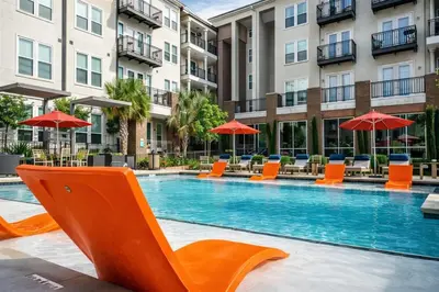 a swimming pool with chairs and umbrellas in a hotel at Modern Apartment Rentals in Los Angeles