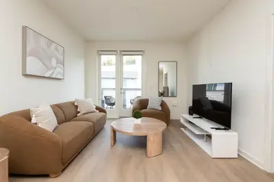 a living room with a couch and a tv and a table at Modern Apartment Rentals in Los Angeles
