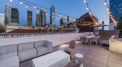 a rooftop patio with a couch and a table and chairs at Modern Apartment Rentals in Los Angeles